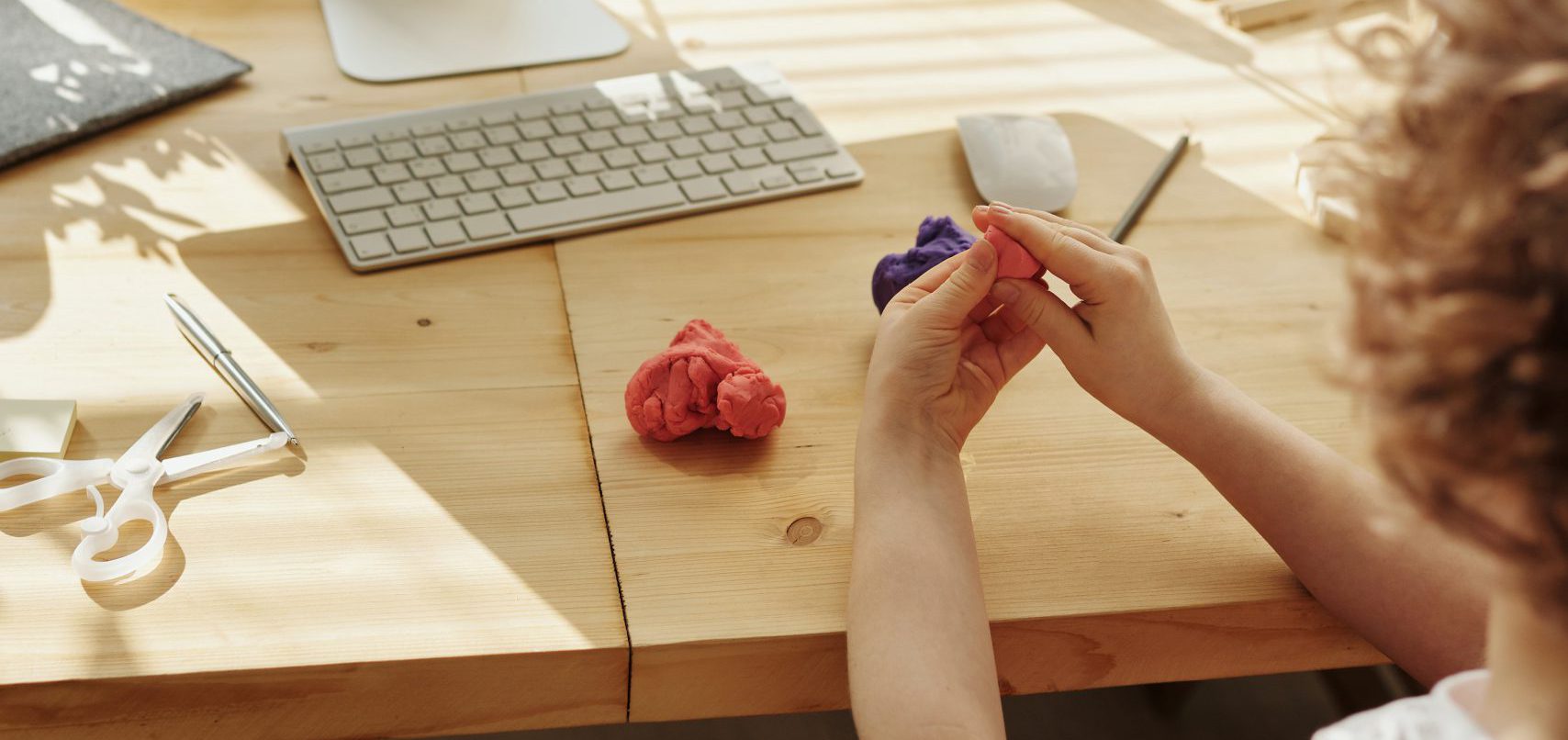 Child Molding Clay In Front of Monitor